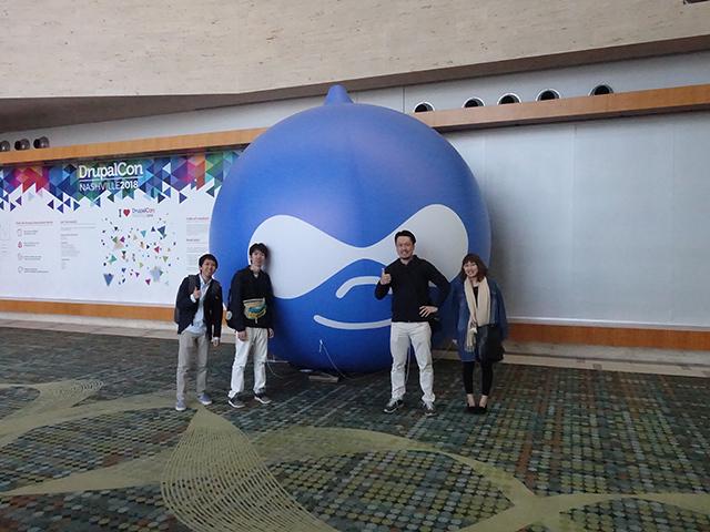 研修を兼ねて海外でのカンファレンスに参加することも。写真はアメリカ ナッシュビルで開催されたカンファレンスに参加した時の様子。Drupalのキャラクター「Druplicon」の前で。