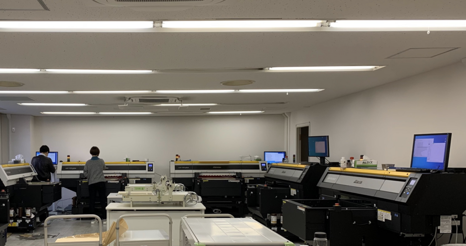 印刷機械を実際に動かして自動化のアイデアを試行している様子です。オペレータのワークフローや作業ルールなども自分達で設計します。