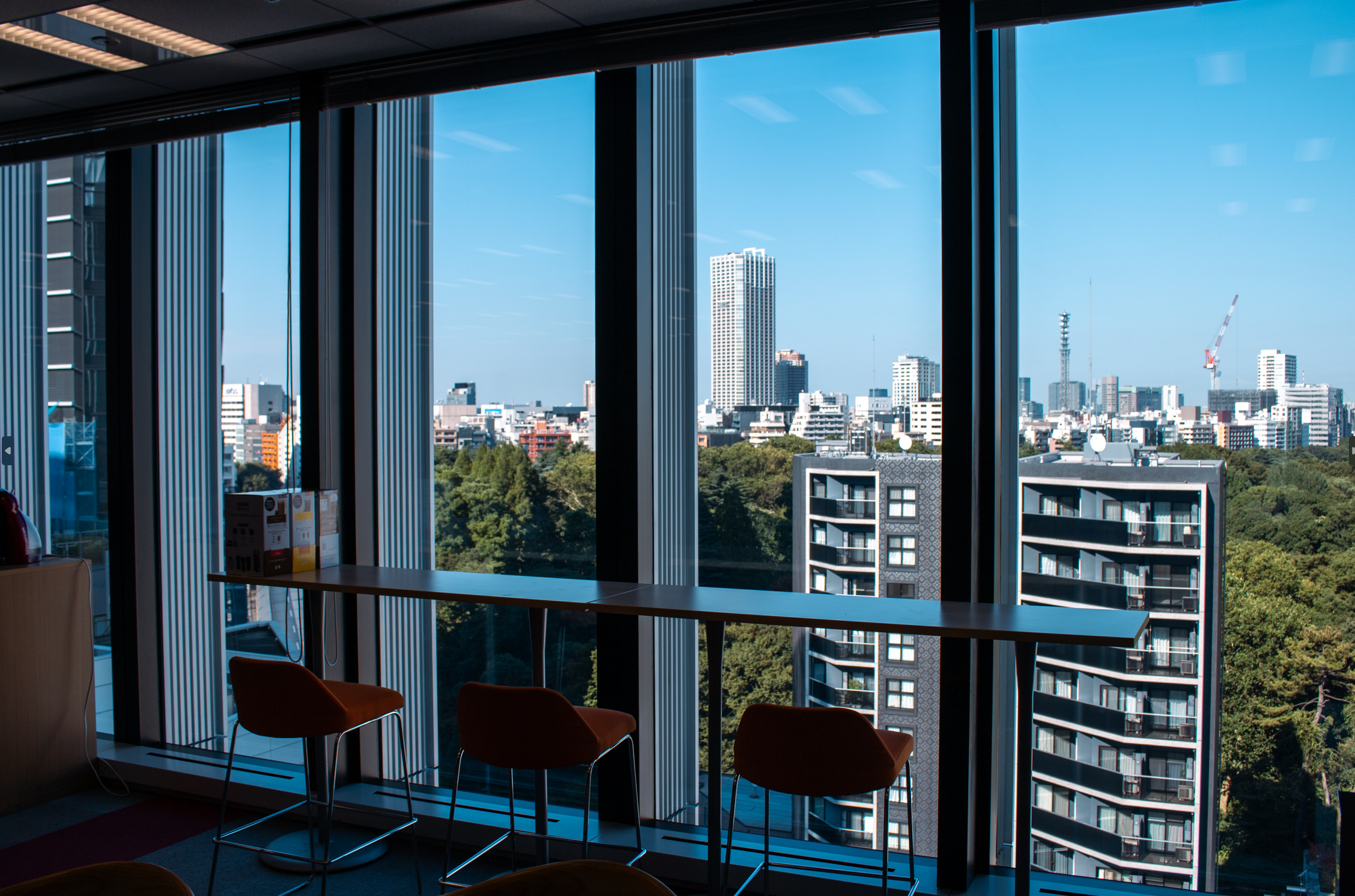 オフィスは新宿から徒歩５分。リモートワークのスタッフと混在している。都心ながら、公園が近くて自然にあふれ、さらにグルメにも恵まれた過ごしやすい場所だ。