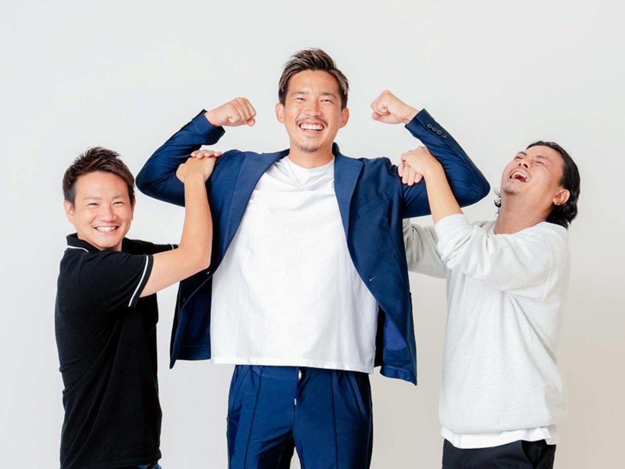 社長の腕にぶら下がる役員二人。チームの結束力と遊び心を表現したユニークで印象的な一枚。