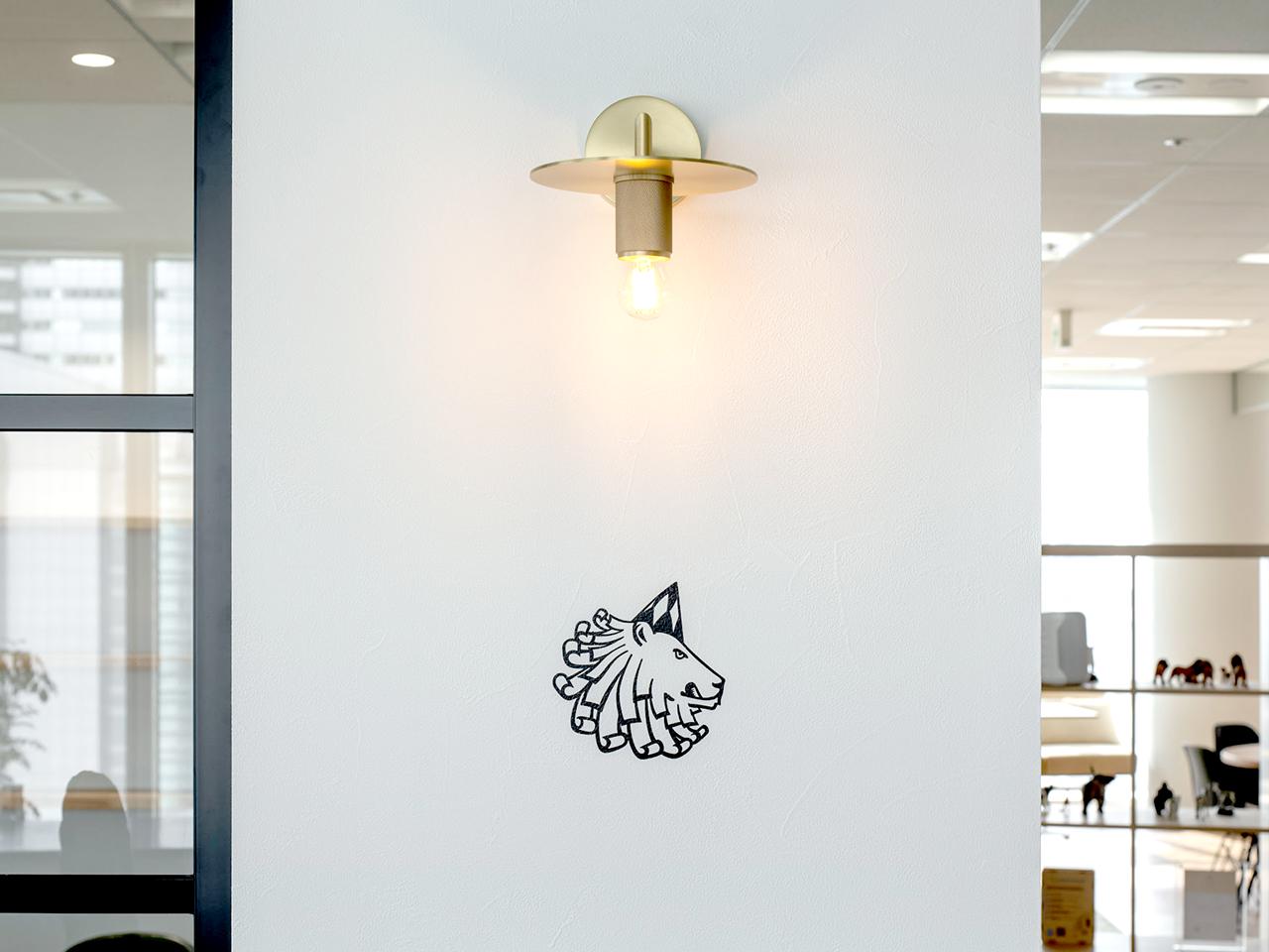 三面採光に白を基調にした明るいオフィス。ゾーニングも回遊性が高く、コミュニケーションが自然と生まれる仕掛けに。真鍮と黒い格子をアクセントにした、経年しても古くならないデザイン。