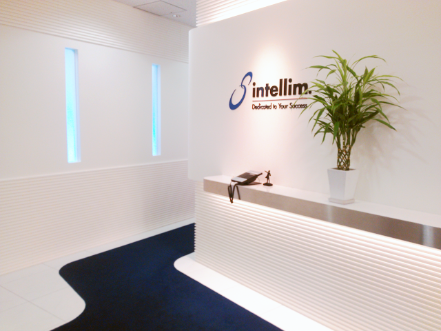 大阪本社のエントランス。白とインテリムブルーで統一され、清潔感を感じる未来的なデザイン。